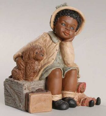 A ceramic figurine of a child sitting on a wooden box, holding a teddy bear.
