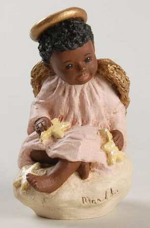 A doll dressed as an angel with a pink dress and wings.