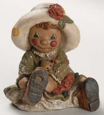 A vintage rag doll with a mushroom hat and rosy cheeks.