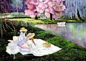 Two women picnic by a river under blooming cherry blossom trees.